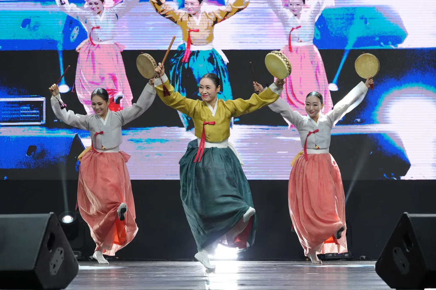 다섯 명의 여성이 전통 한복을 입고 무대 위에서 소고와 춤을 추며 공연하는 모습.