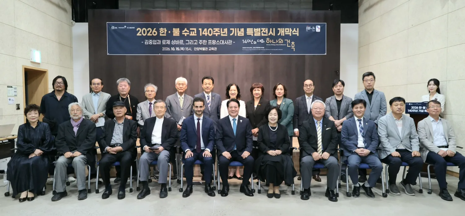 실내 공간에서 다양한 연령과 성별의 27명이 줄지어 앉거나 서서 카메라를 바라보는 단체 사진.