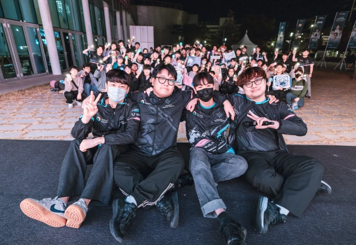 야외에서 이스포츠 선수들과 팬들이 모여 함께 사진을 촬영하는 단체 모습