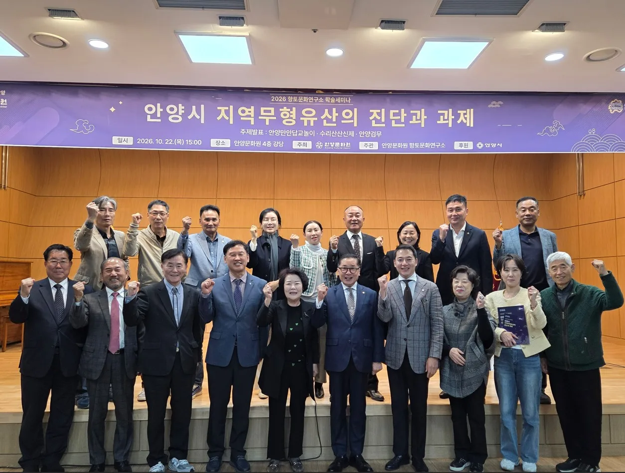 강당 무대 앞에서 단체로 포즈를 취한 세미나 참석자 20여명 모습