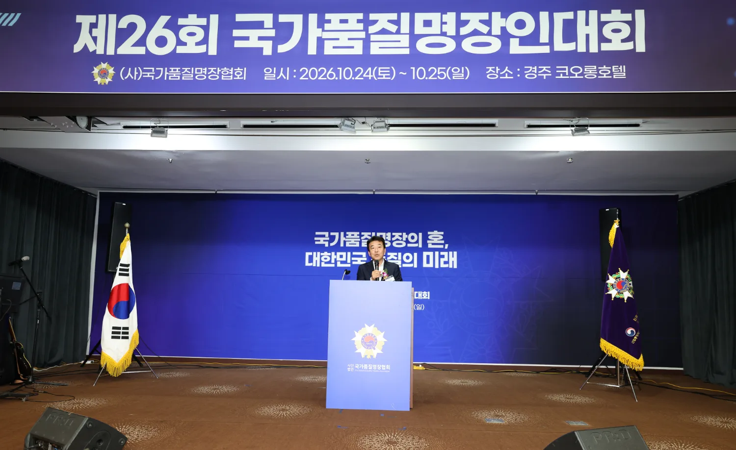 연단에 서서 축사하는 최혁준 경주시 부시장과 양옆의 태극기와 행사 깃발