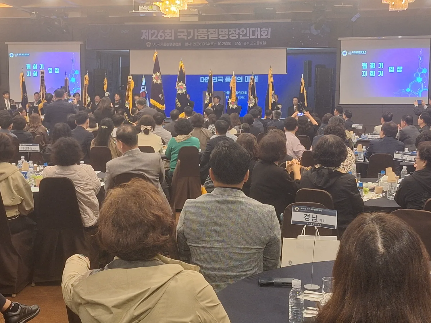 국가품질명장인 대회 행사장에서 많은 참석자가 테이블에 앉아 행사를 보고 있는 장면