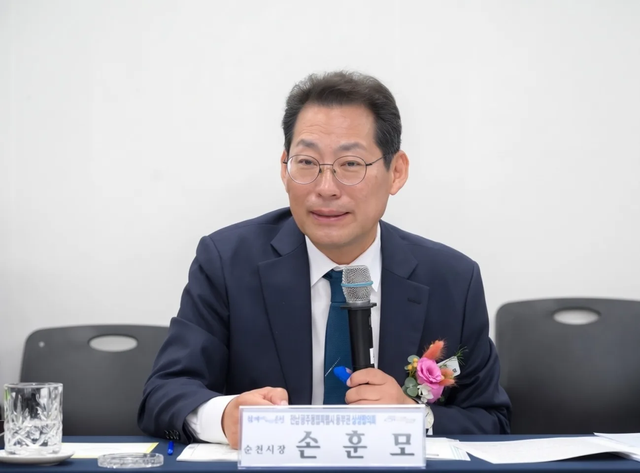 정장 차림의 손훈모 순천시장으로 보이는 남성이 마이크를 잡고 이야기하는 모습